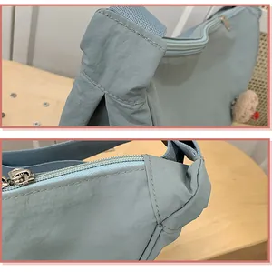 Gros plan sur les coutures et la fermeture éclair d'un sac en nylon bleu clair