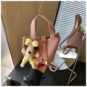 Elegant pink pebbled leather bucket bag with gold lock and cute plush dog charm detail