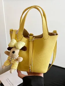 Stylish vibrant yellow pebble leather bucket bag with cute puppy charm crossbody handbag