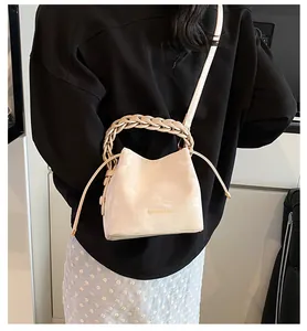Detailed view of the stylish cream drawstring bucket bag worn as a crossbody style