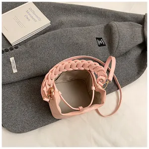 Detailed top view of a pink bucket bag showing the interior lining and braided handle detail