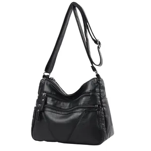 Vintage black soft leather crossbody bag with multiple zipper pockets on white background