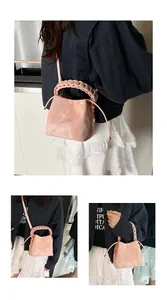 Detail view of a stylish pink bucket bag featuring a unique braided handle and drawstring