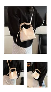 Model wearing a cream bucket bag with unique braided handle and crossbody strap