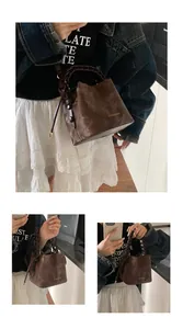 Detail view of Korean style brown bucket bag with unique braided handle and chic gold logo
