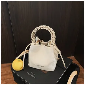 Niche design creamy white women's bucket bag with a stylish braided handle and drawstrings.