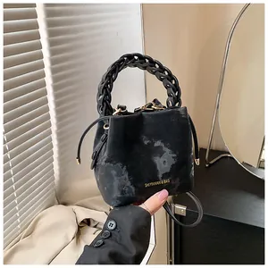 Close-up detail of a black tie-dye bucket bag featuring a unique chunky chain link handle
