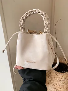 Elegant cream white bucket bag with a stylish braided handle and subtle marble texture