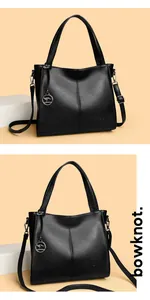 Detailed view of black leather multi-compartment shoulder bag with kangaroo charm
