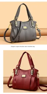 Detalle de bolsos de mano grises y rojos de gran capacidad y textura de cuero elegante.