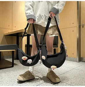 Gros plan de sacs croissant en nylon noir avec de jolis badges.