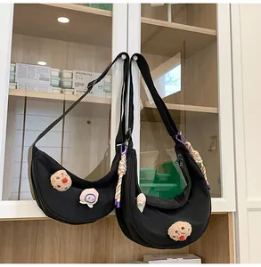 Vue détaillée de deux sacs croissant en nylon noir avec écussons en peluche et cordes
