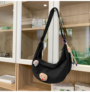 Vue détaillée d'un sac demi-lune japonais en nylon noir avec des épingles décoratives