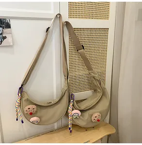 Vue détaillée de deux sacs dumpling en nylon kaki avec des écussons en peluche