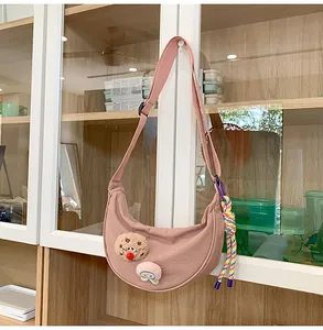 Sac à bandoulière croissant en nylon rose suspendu à une étagère, vue détaillée