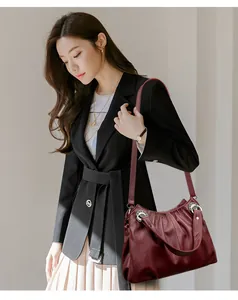 Bolso de hombro de cuero plisado burdeos grande usado por una modelo en detalle