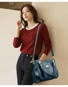 Elegante modelo asiática llevando un gran bolso de hombro azul de cuero granulado