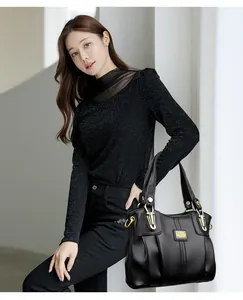 Elegante bolso de mano de cuero negro para mujer con detalles dorados