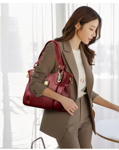 Elegante bolso de mano grande color burdeos llevado por modelo profesional en traje
