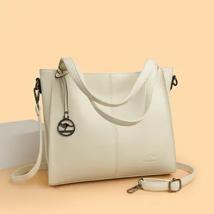 Elegant cream white pebble grain leather shoulder bag featuring a kangaroo charm