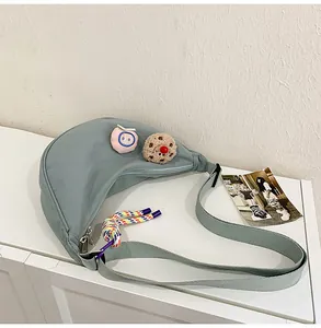 Détail du sac à bandoulière en nylon bleu clair avec patchs décoratifs mignons et colorés