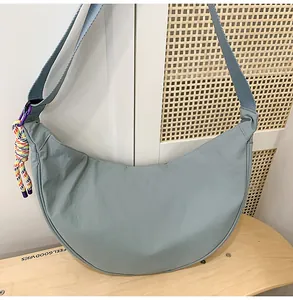 Détail d'un sac à bandoulière décontracté en nylon bleu clair sur un tabouret en bois