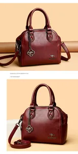 Vista dettagliata di una borsa a mano in pelle rossa con manici eleganti e tracolla
