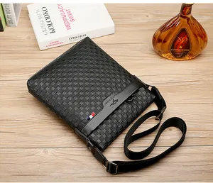 Vue détaillée d'une sacoche en cuir noir à damier de luxe pour homme sur un bureau