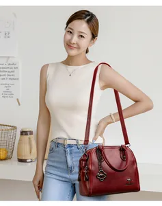 Dettaglio di un'elegante borsa a mano in pelle rosso scuro con modella