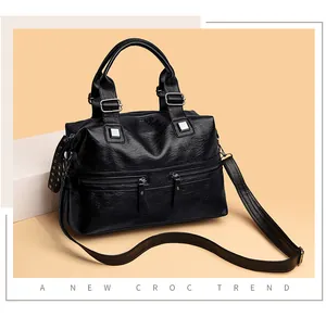 Schwarze Handtasche aus strukturiertem Leder mit Reißverschlüssen und Schultergurt