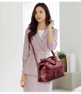 Asiatisches Model mit großer weinroter Mehrfachtaschen-Tragetasche für Reisen.