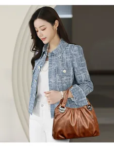 Elegante bolso de mano de cuero plisado marrón para mujer, lucido por una modelo.