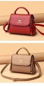 Detailed view of fashionable red and taupe textured leather handbags with kangaroo logo.