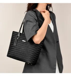 Professional model carrying a black woven PU leather tote bag for a commuter style look