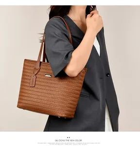 Detailed side view of a brown woven PU leather tote bag elegantly worn by a model
