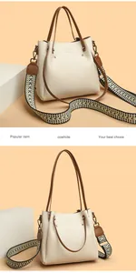 Elegante bolso de mano de cuero crema con correa ancha estampada y logo de canguro