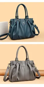 Detalle de bolsos de cuero en azul y gris con pliegues elegantes y logo de canguro