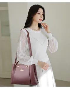 Elegante modelo presentando un bolso morado de moda con logo de canguro dorado