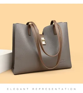 Détail du sac cabas élégant en cuir gris texturé avec fermoir doré tournant.