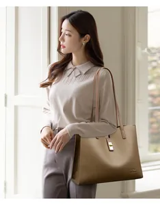 Élégant mannequin asiatique portant un grand sac cabas en cuir marron clair de luxe