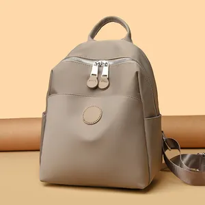 Stylish minimalist beige waterproof nylon backpack for women, perfect for travel and commuting