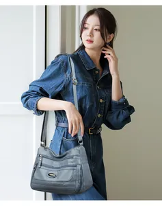 Detailed view of grey washed leather shoulder bag with multi-pockets on a model