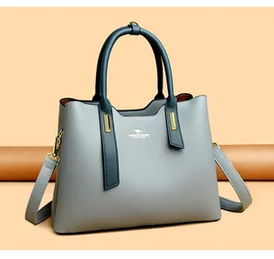 Vista dettagliata di un'elegante borsa in pelle PU grigia e verde petrolio con oro