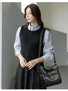 Detailed view of black washed leather crossbody bag with multiple zipper pockets.