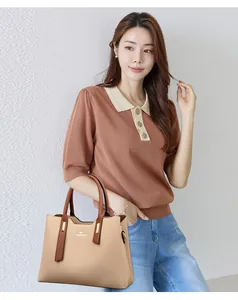 Elegante borsa a mano da donna in pelle PU bicolore beige e marrone portata da una modella
