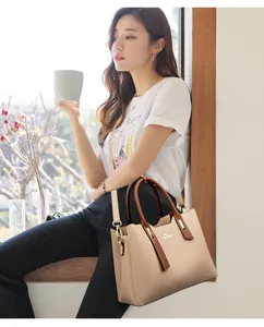 Elegante borsa tote in pelle PU bicolore indossata da una modella asiatica in scena