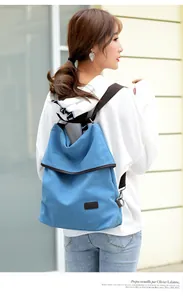 Detailed view of the blue canvas backpack worn by a model in casual outdoor setting.