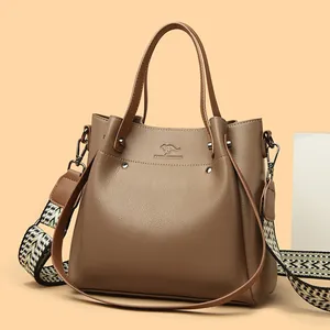Elegante bolso de mano de cuero marrón con bandolera ancha de jacquard
