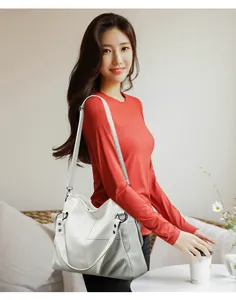 Elegante bolso de mano de cuero PU blanco con diseño empalmado en una modelo