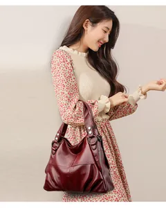 Vista de estilo de vida de un bolso tote grande de cuero PU burdeos llevado por modelo